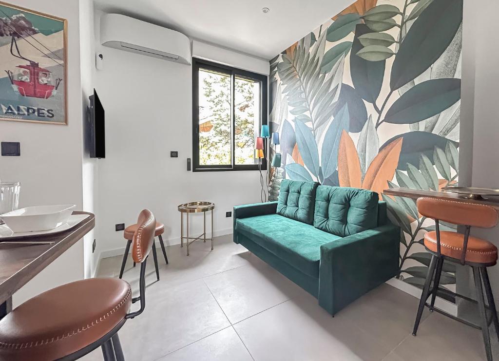 un salon avec un canapé vert et une fresque murale. dans l'établissement 103 appartement 1 chambre élégant et lumineux avec Terrasse, à Grenoble