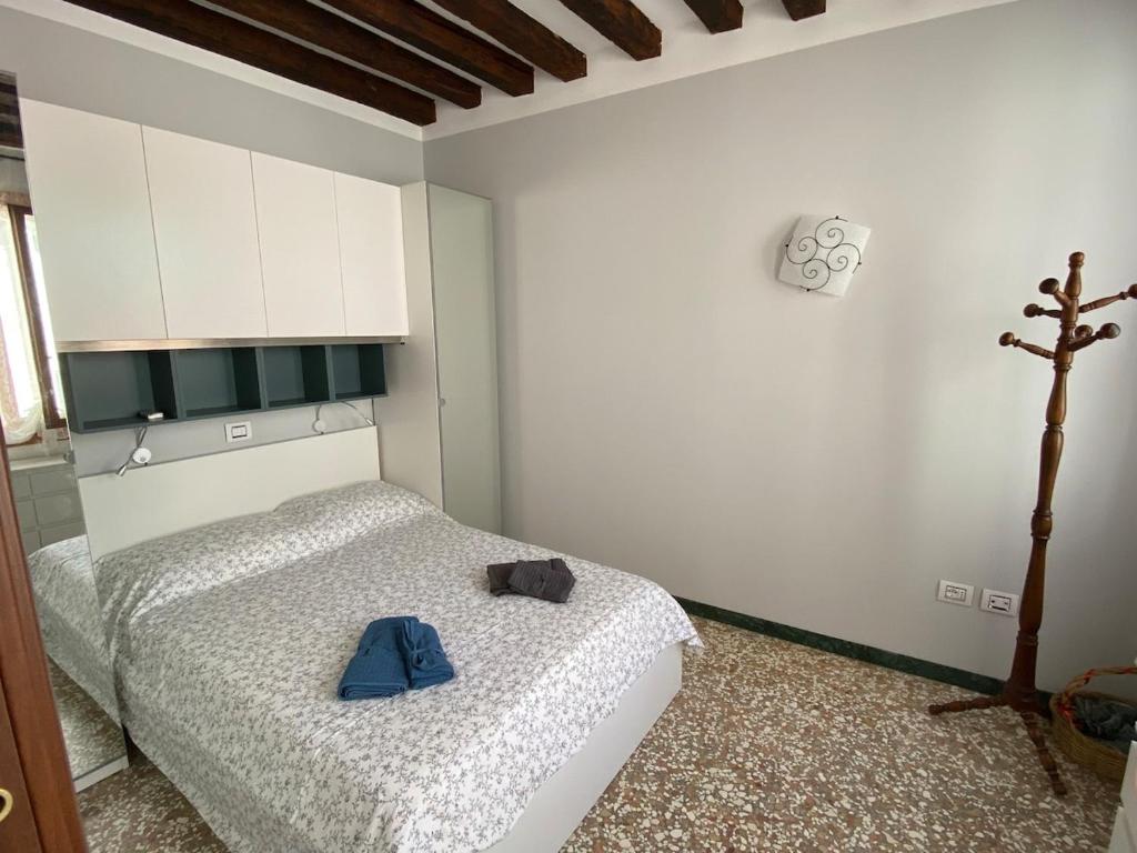 a bedroom with a bed with a blue shirt on it at Casa MammaMarisa in Murano