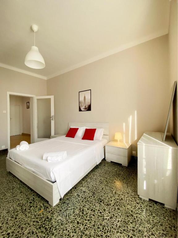 a bedroom with a large white bed with red pillows at Comodo e Pratico nel Cuore pulsante di Pisa in Pisa
