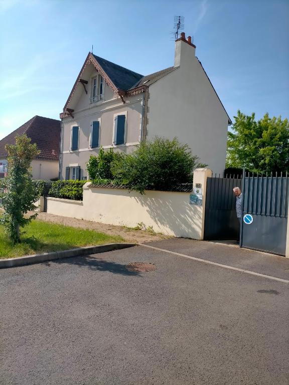 une maison blanche avec un portail et une clôture dans l'établissement Jadis sous la gloriette, à Sancoins