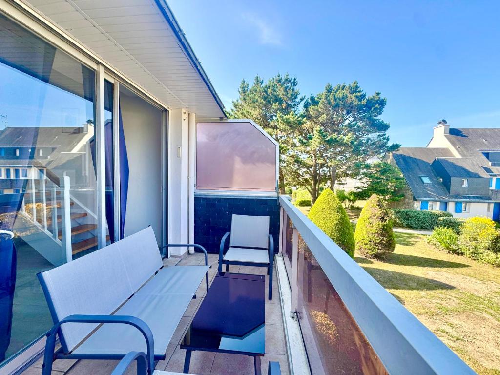 - un balcon avec deux chaises et un banc dans l'établissement Appartement Duplex - Proche Plage, à Carnac