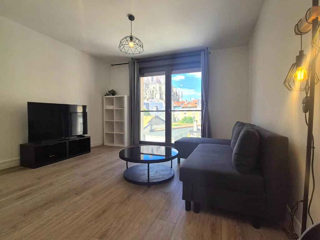 un salon avec un canapé, une table et une télévision dans l'établissement Sídney, 6 Pers, Hyper-centre, Cathédrale, à Reims