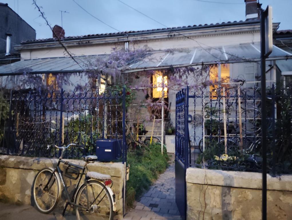 un vélo garé devant une clôture dans l'établissement Pretty house, à Bordeaux