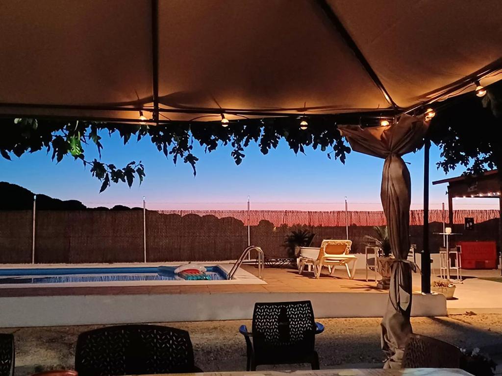 a view of a pool with chairs and an umbrella at Villa La Espiga in Valladolid