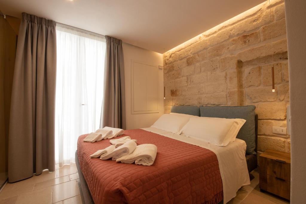 a bedroom with a bed with towels on it at Le Quattro Perle in Monopoli