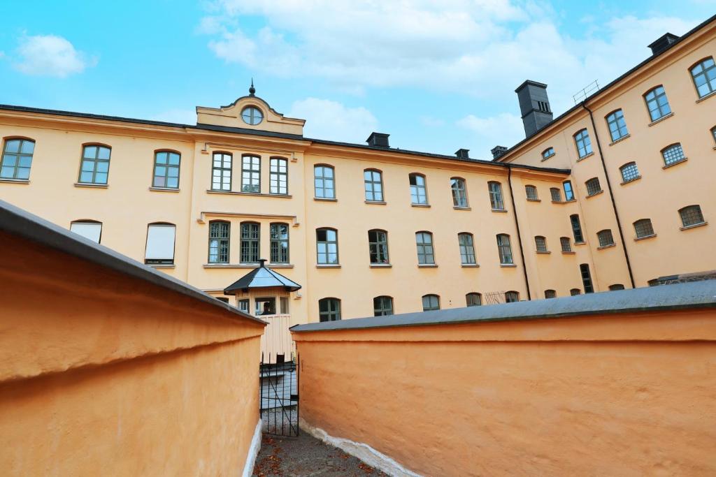 ein großes Gebäude mit einer Uhr darüber in der Unterkunft STF Långholmen Hostel in Stockholm