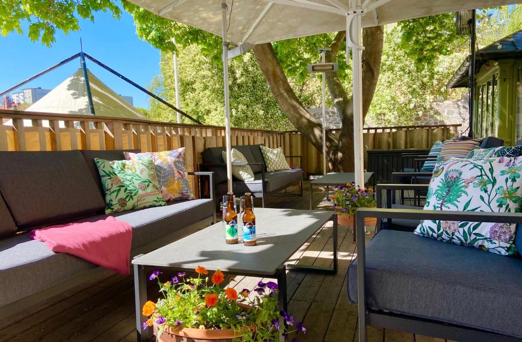 eine Terrasse mit Sofas und einem Tisch mit Getränken darauf in der Unterkunft STF Långholmen Hostel in Stockholm