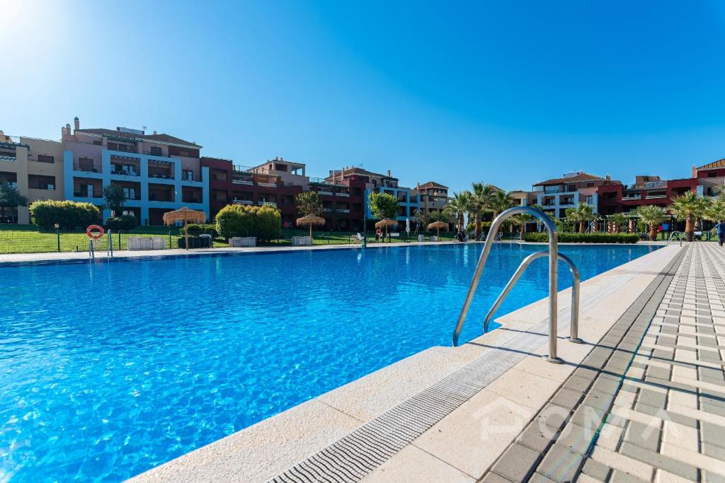 a swimming pool in a resort with buildings in the background at El Rincón del Golf III by Ĥ - Isla Canela Golf GRHIII88P88 in Isla Canela