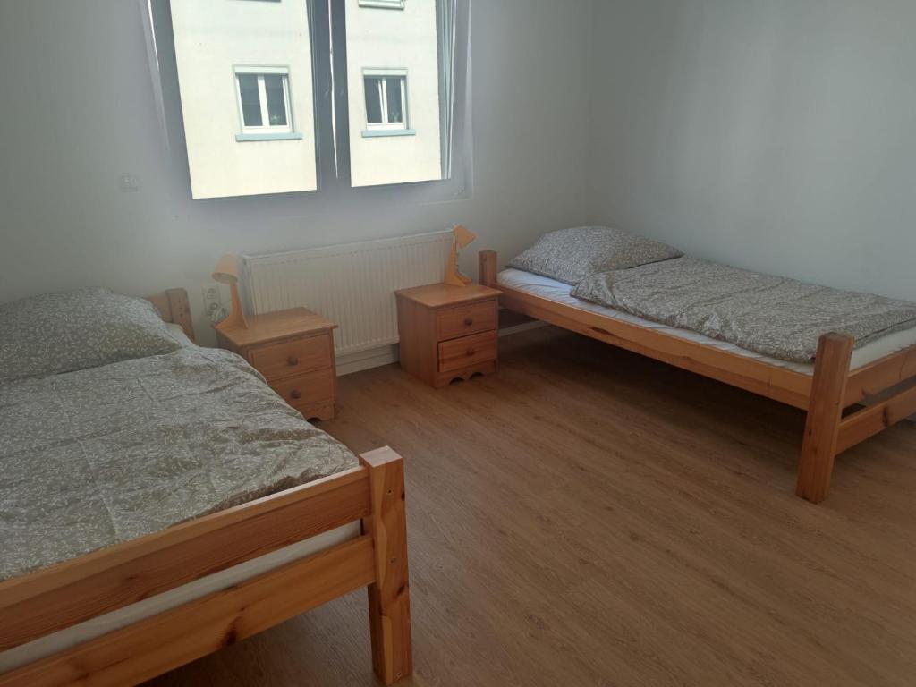 une chambre avec deux lits et une fenêtre dans l'établissement Monteurzimmer Mühlheim am Main Nähe S-Bahn, à Mühlheim am Main