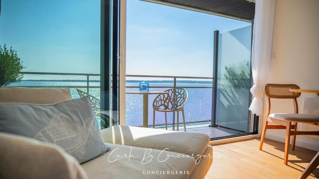 d'un salon avec un canapé et un balcon. dans l'établissement Le RÊVE BLEU CONCARNEAU 2 pers face à la mer, à Concarneau