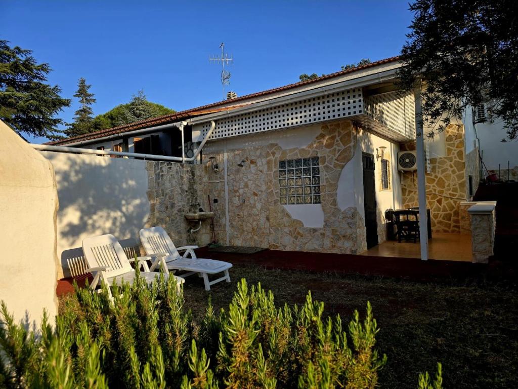 a house with two white chairs and a patio at MERCADANTE - Luxury Holiday House in Cassano delle Murge