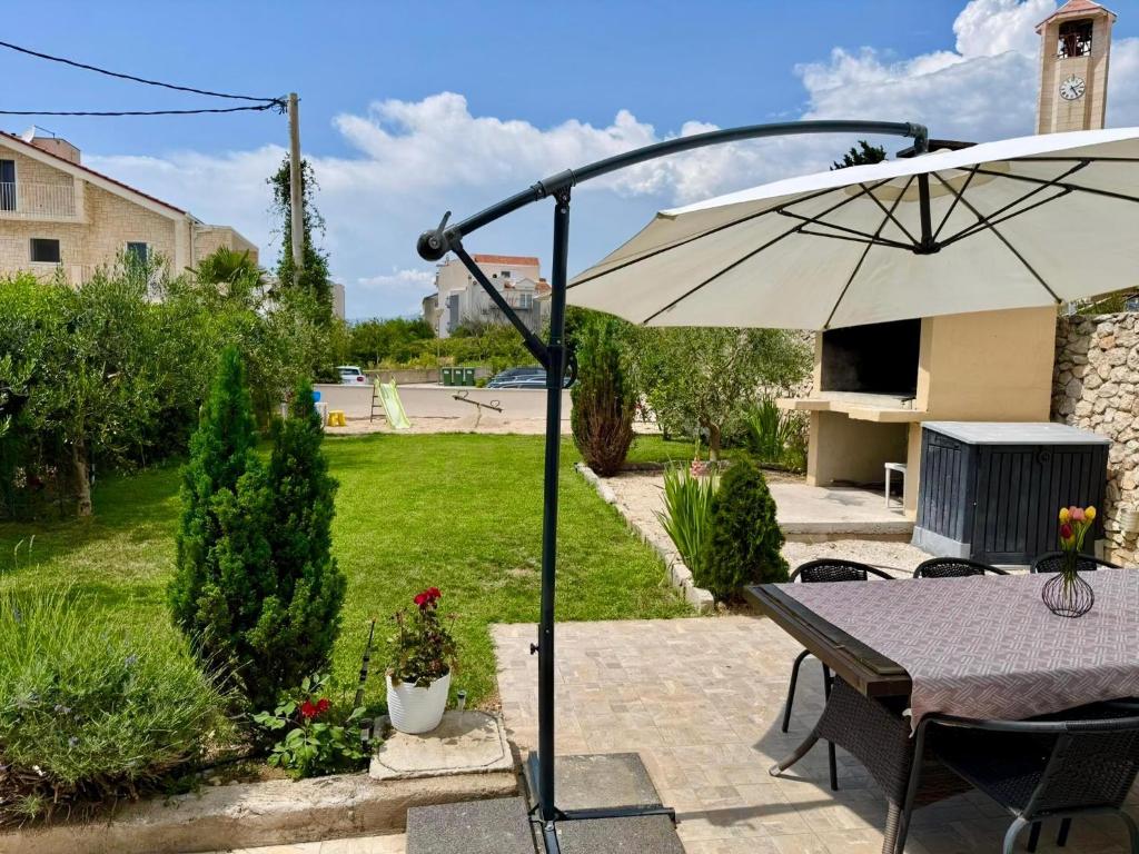 eine Terrasse mit Tisch und Sonnenschirm in der Unterkunft Ferienwohnung für 8 Personen ca 85 m in Podstrana, Dalmatien Mitteldalmatien in Podstrana