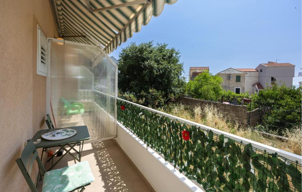 - un balcon avec une table et des fleurs rouges dans l'établissement Nice Apartment In Podgora With Wifi, 