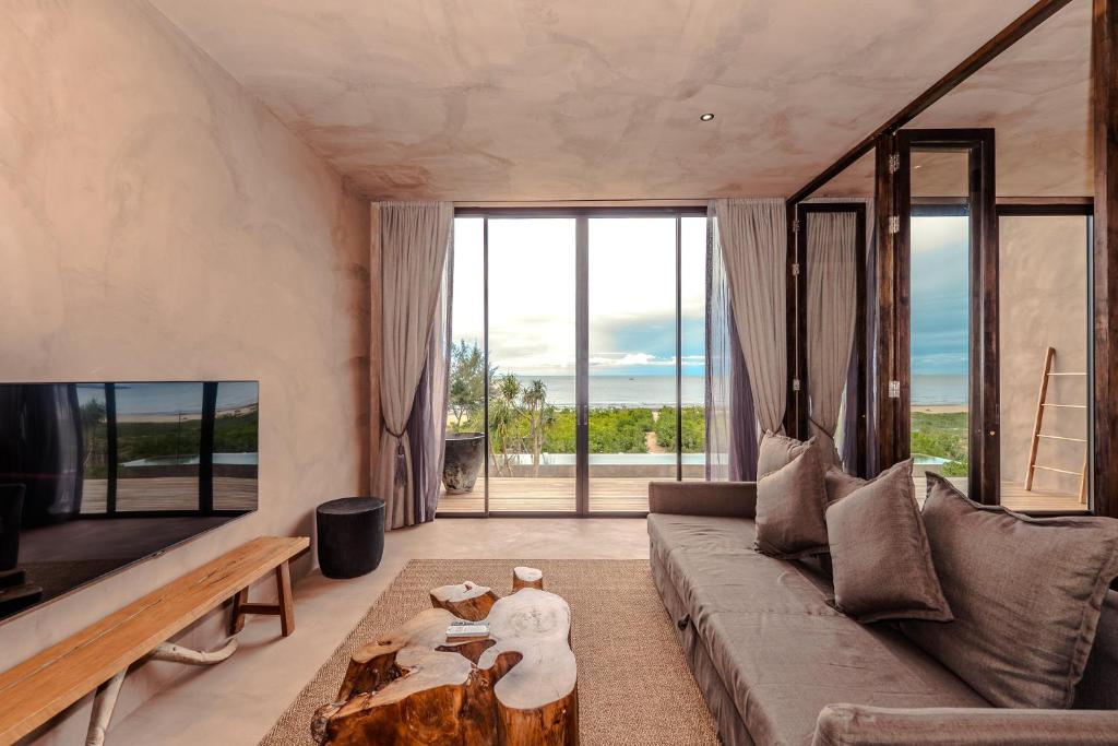 a living room with a couch and a table at inchantreedoolay huahin in Pran Buri