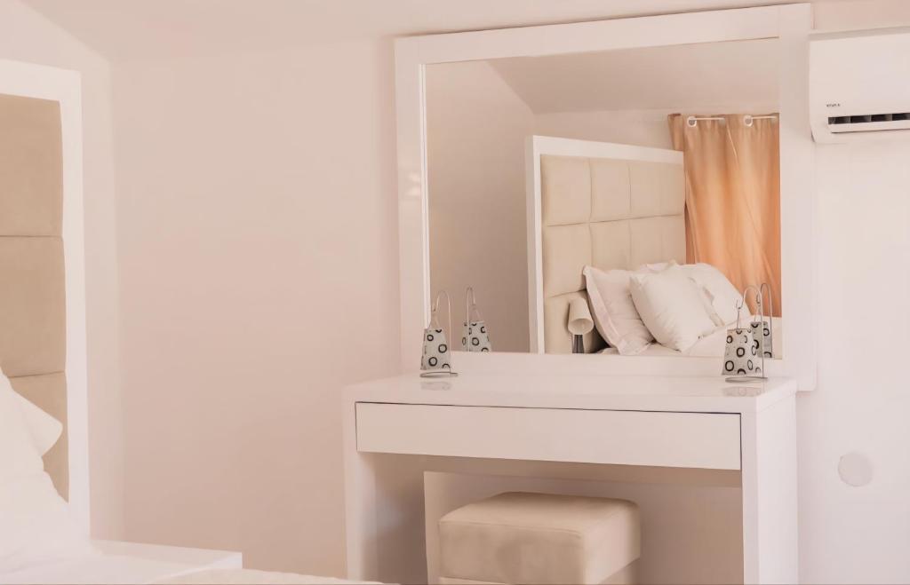 a white bathroom with a sink and a mirror at Sea side apartment in Kotor