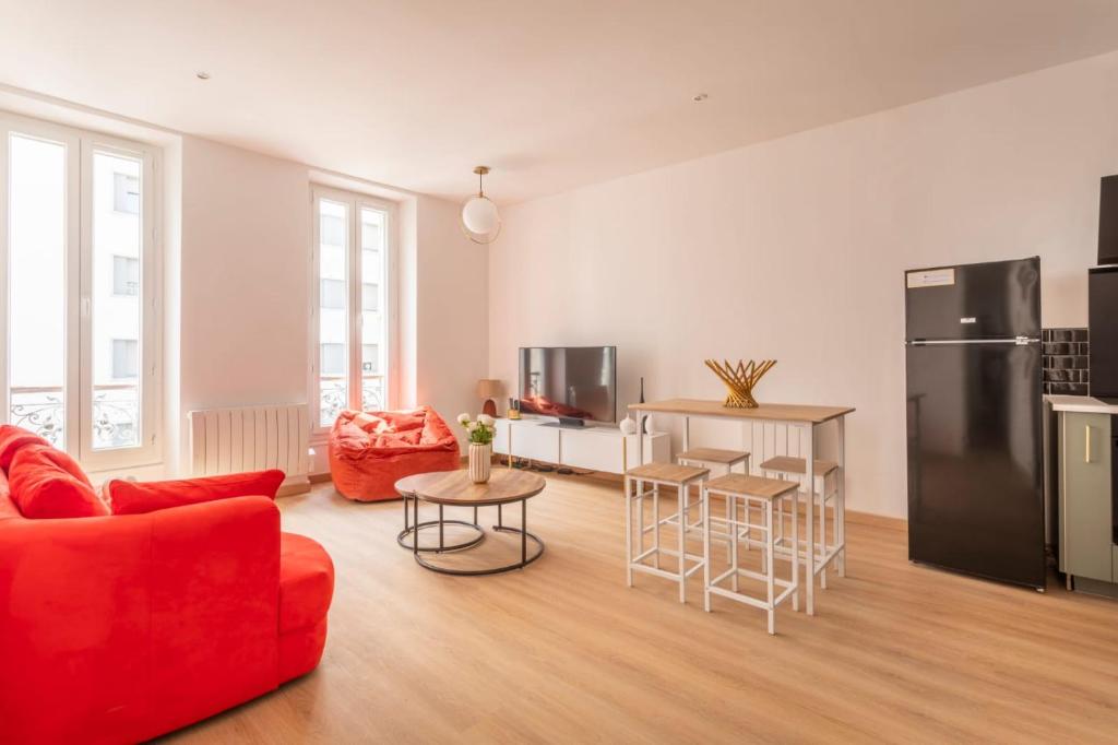 un salon avec un canapé rouge et une cuisine dans l'établissement T3 spacieux et lumineux, à Marseille