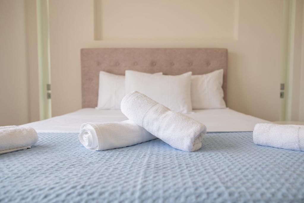 two rolls of white towels sitting on a bed at Balance Suite in Kourouta