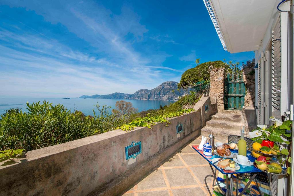 a table with food on it next to the ocean at Casa Il Geco Praiano in Praiano