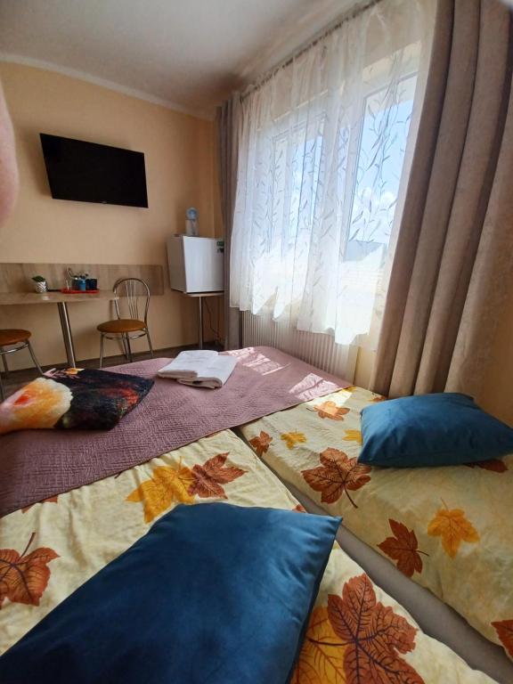 zwei Betten in einem Zimmer mit Fenster in der Unterkunft Pensjonat Pod ósemką Mielno in Mielno