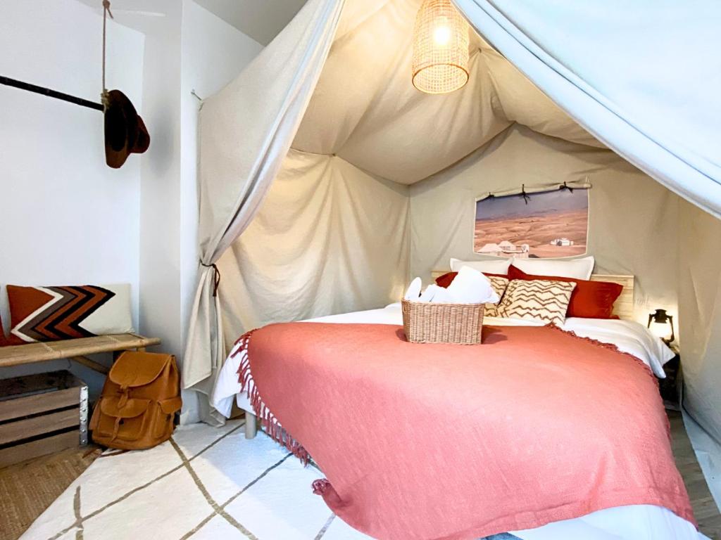 une chambre avec un lit dans une tente dans l'établissement L'Expédition - By BEST KEYS - Expérience Unique - Déco Immersive - Lit Queen Size & Canapé Convertible - Centre Ville - Smart TV - Machine à Café Nespresso - Netflix & WiFi ILLIMITÉ - Check-in Autonome - Parking Gratuit, à Villeneuve-sur-Yonne