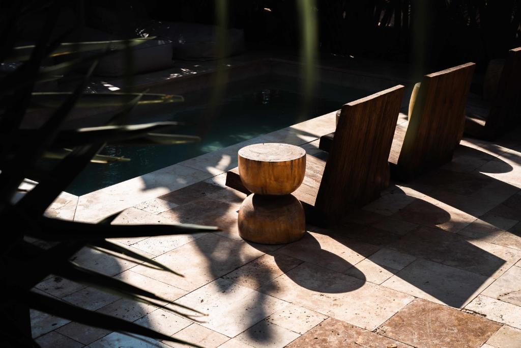 a wooden stump bench sitting next to a pool at Hotel Anilevich Mansion in Beer Sheva