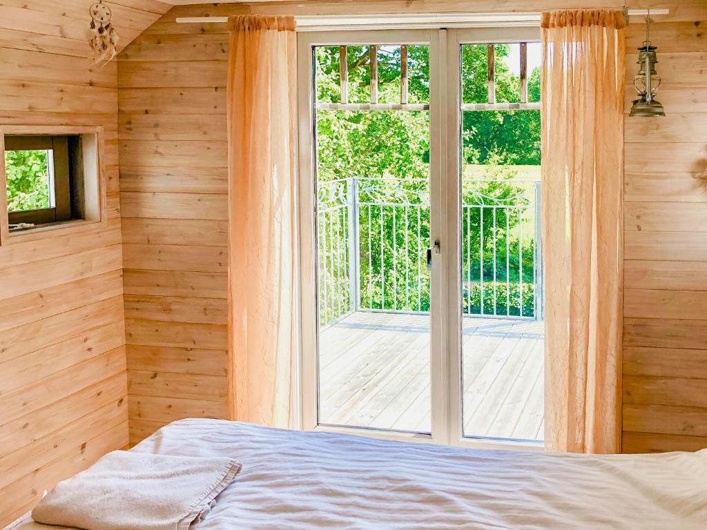 a bedroom with a bed and a large window at Timber-Framed House With Organic Farm In Nature in Stehag