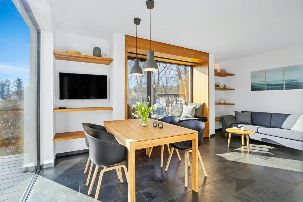 Un comedor y una sala de estar con mesa y sillas. en Light Flooded Holiday House On The Baltic Sea, en Ahrenshoop