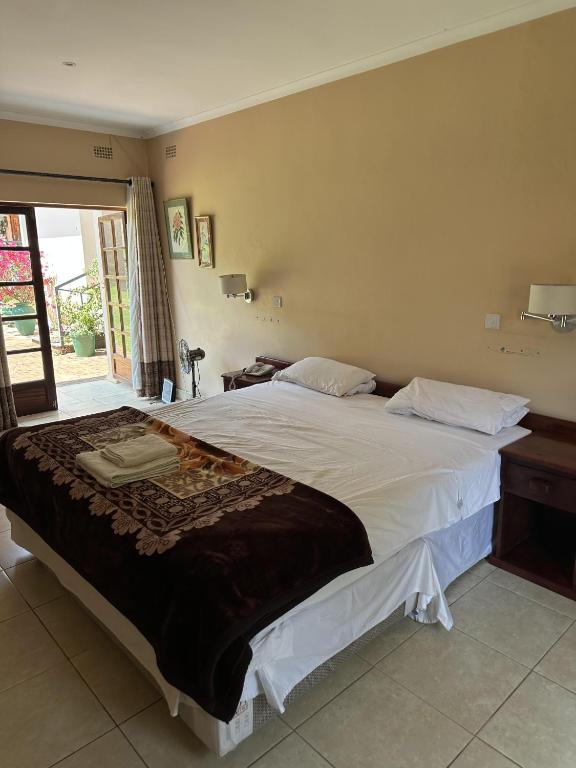 a bedroom with a large bed in a room at A boutique lodge situated in a serene environment - 2026 in Harare