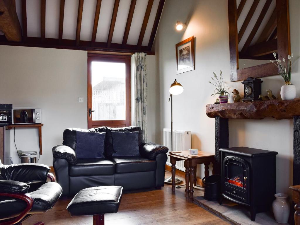 un soggiorno con divano e camino di Byre Cottage - Meadowbrook Farm a Thame