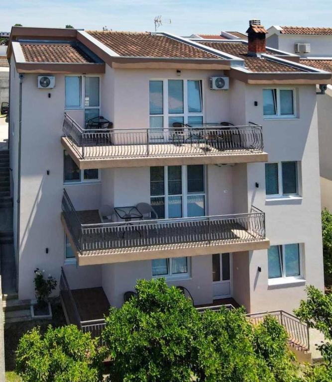 an apartment building with balconies and trees at Kasneci Apartments in Ulcinj