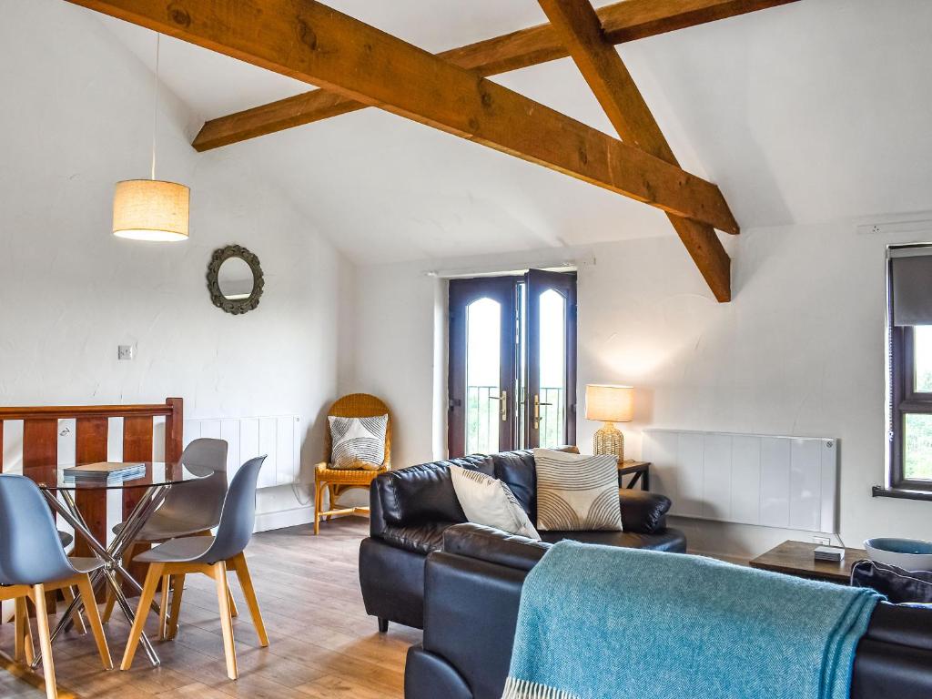 ein Wohnzimmer mit Sofa und Tisch in der Unterkunft Dizzard Cottage in Bude