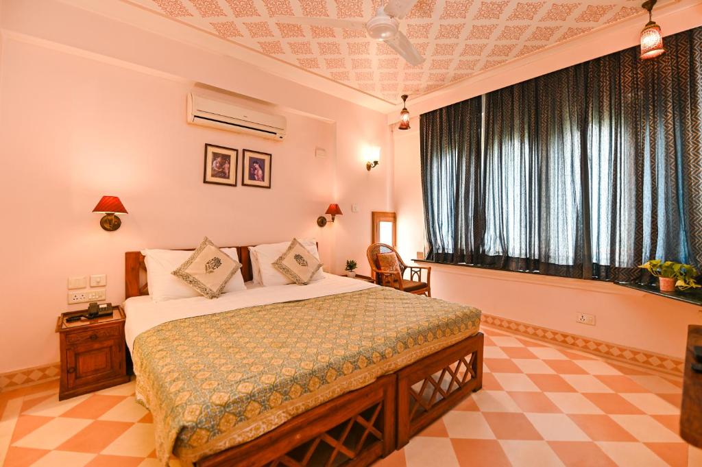 Postel nebo postele na pokoji v ubytování Om Niwas Suite Hotel