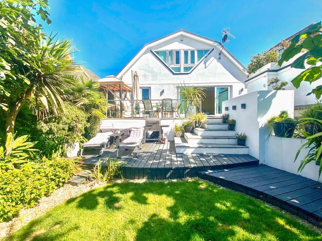 a white house with a patio and grass at Gorsehill House in Poole