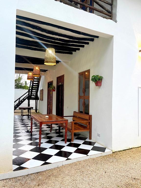 a room with a table and a checkered floor at Tulivu Zanzibar in Bwejuu