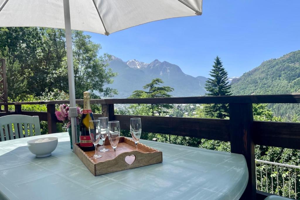 - une table avec des verres à vin et un parasol sur le balcon dans l'établissement Apartment for 4 with with nice view of Briançon, à Briançon