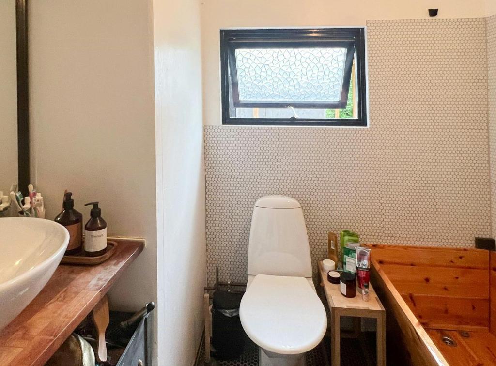 een badkamer met een wit toilet en een wastafel bij Japanese-Inspired Nature Gem In Vejby Strand in Vejby