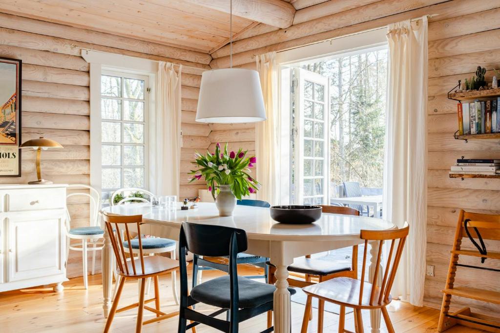 a dining room with a table and chairs at Cozy Times In Log House Amongst Trees in Ebeltoft