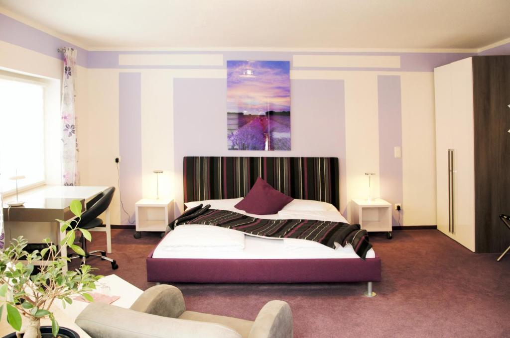 a bedroom with a large bed and two chairs at Park Ambiente Friedberg in Friedberg