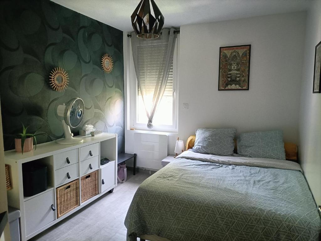 une chambre avec un lit, une commode et une fenêtre dans l'établissement appartement Deux pièces au calme, à Toulouse