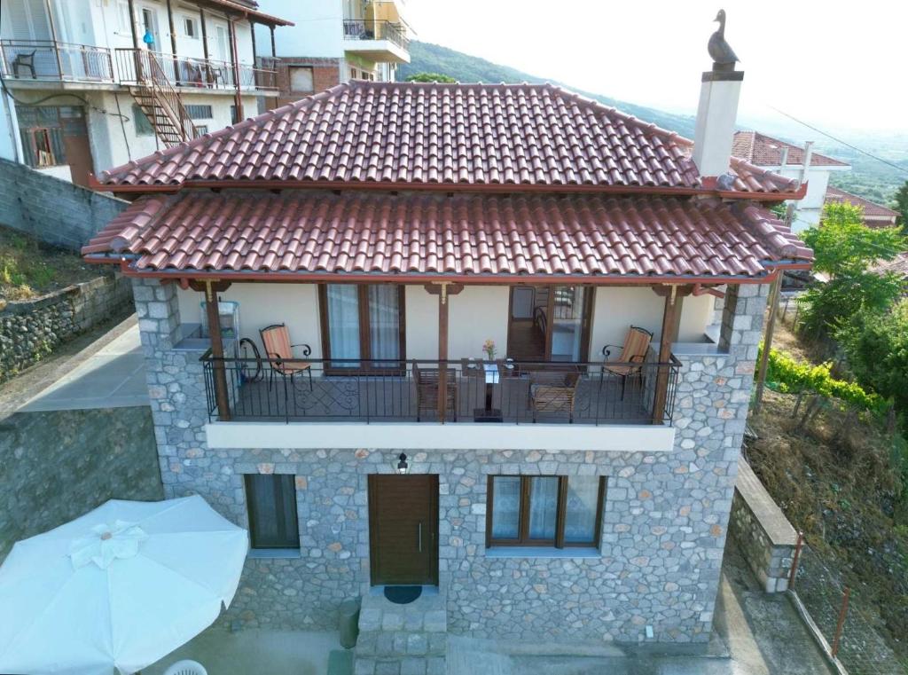 a small house with a balcony and an umbrella at Helena's House in Ipáti