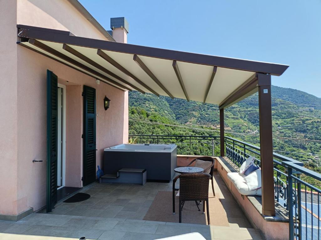 a patio with a roof with a hot tub and a table at La Cabana Cinque Terre Monterosso in Monterosso al Mare