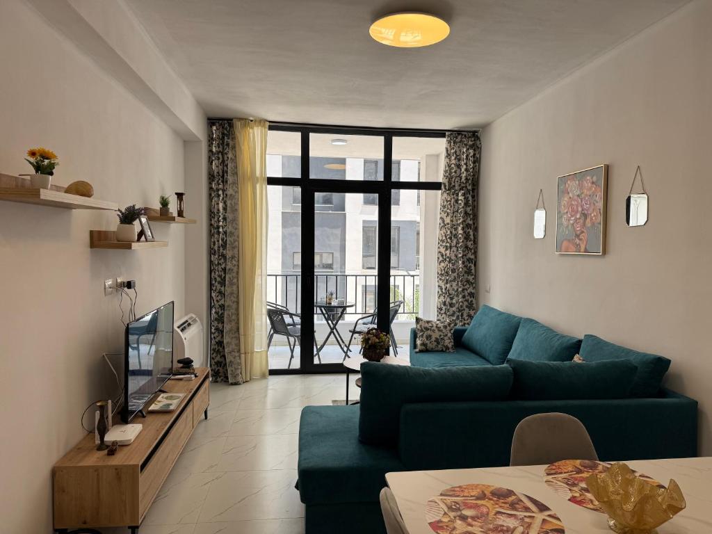a living room with a green couch and a television at Flat in Orikum Beach in Orikum