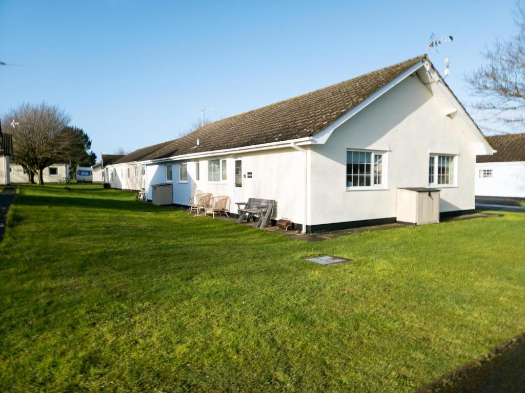 a white house with a large yard at Eddies - 2 Bedroom Chalet – Scurlage in Knelston