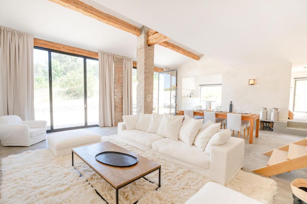 un salon avec un canapé blanc et une table dans l'établissement La Bergerie Ferme du Montaiguet, à Aix-en-Provence