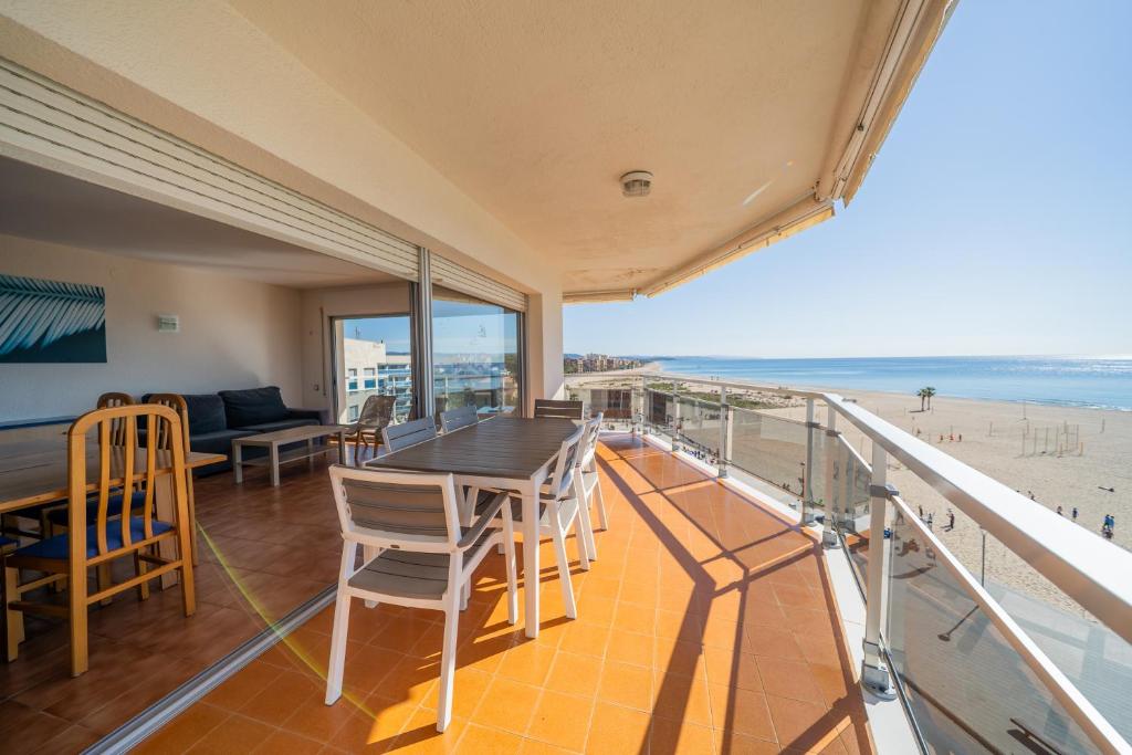 a balcony with a table and chairs and the beach at Apartaments Lamoga - Monteixo in Torredembarra