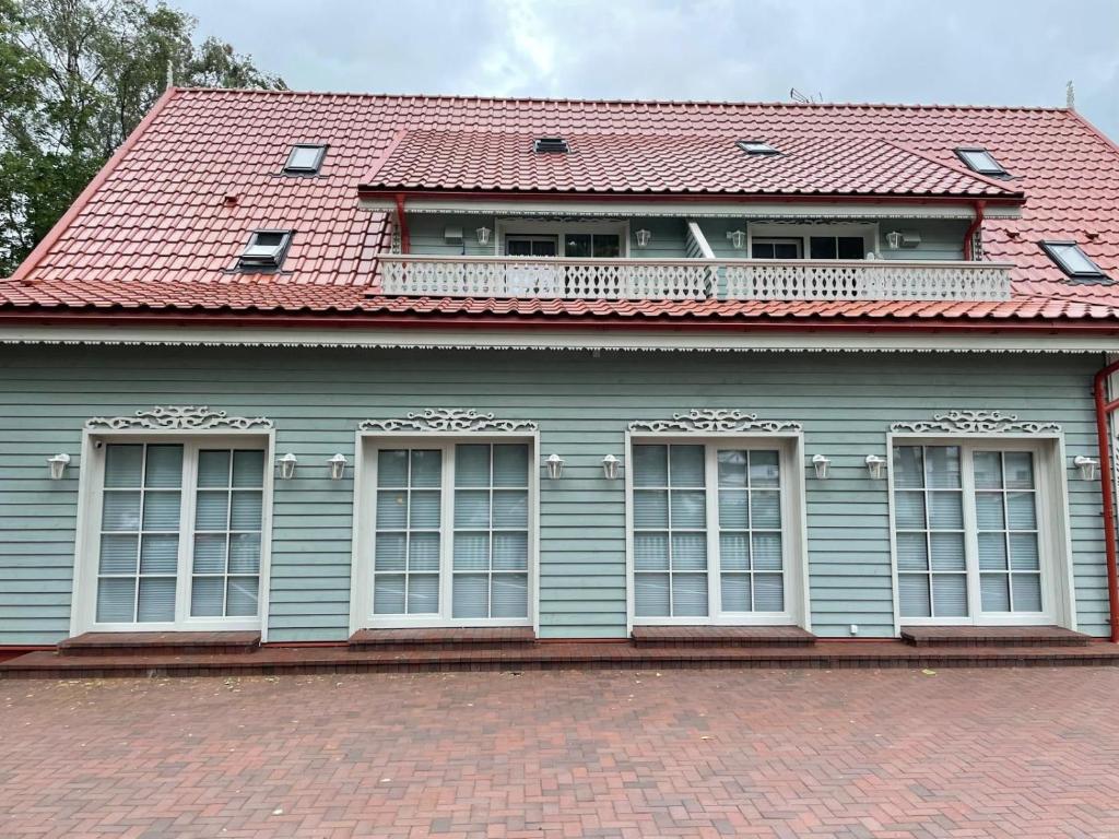 パランガにあるBirutės alėja 18の赤い屋根と窓のある青い家