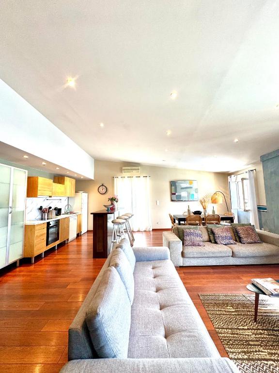 a large living room with two couches and a kitchen at Appartement vue mer Christophe Colomb 140m2 in Calvi