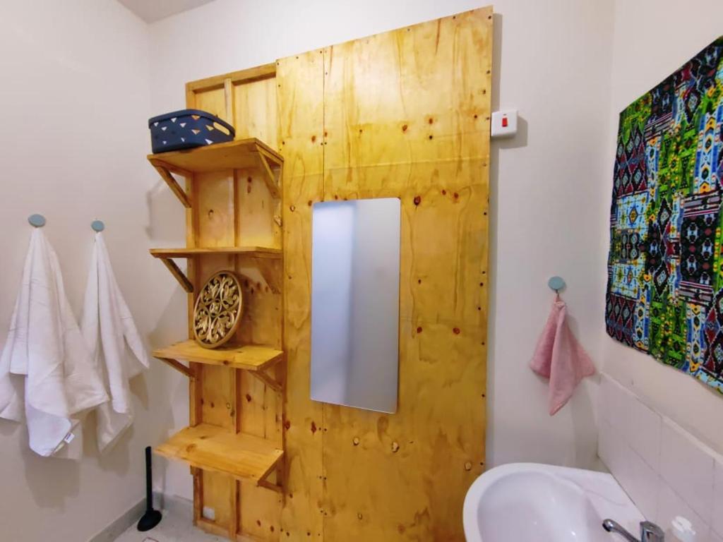 un baño con espejo y lavabo en Terry Homes, en Mombasa