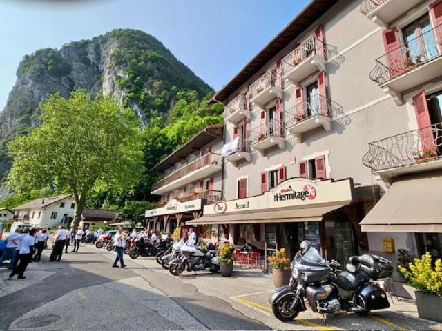 Un grupo de motocicletas estacionadas frente a un edificio. en Hôtel et appart'hôtel de l'Hermitage, en Thônes