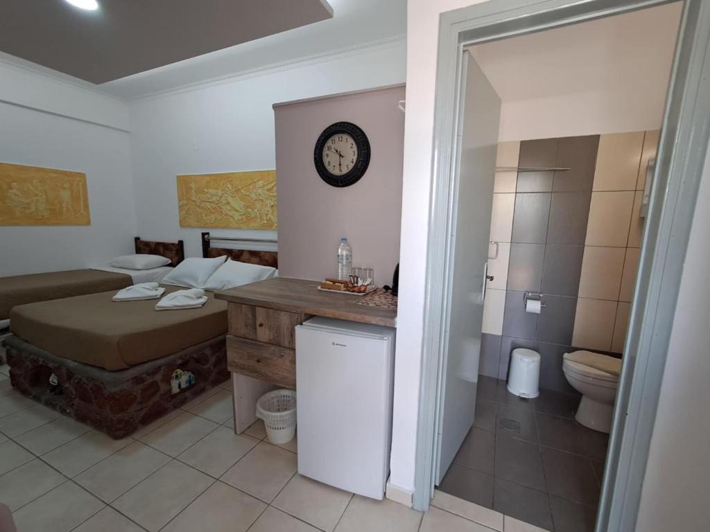 bagno con letto, servizi igienici e lavandino di Villa Nektaria a Perissa